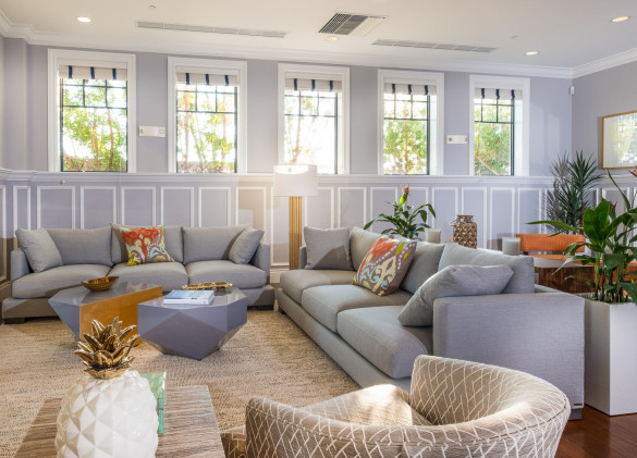 clubhouse interior of grey couches and chairs in a brightly lit room