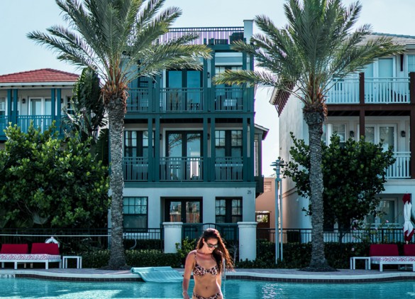 woman walking out of the pool with homes in the background