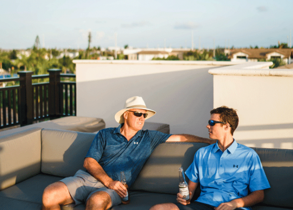 two men relaxing on outdoor patio furniture enjoying conversation