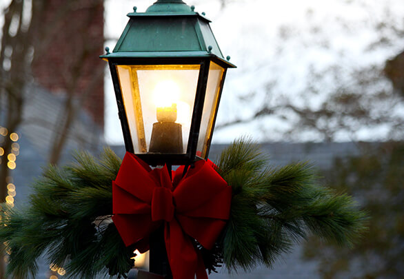 close up view of a lightpost with a christmas ribbon