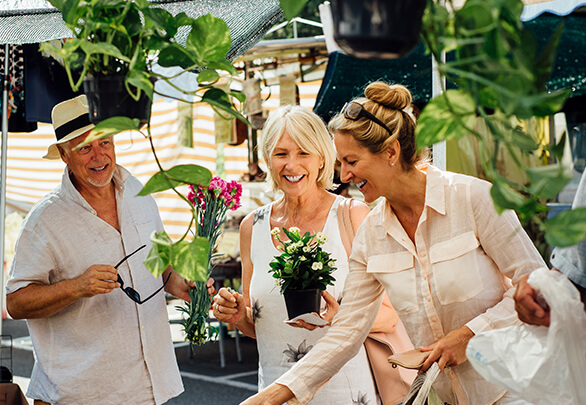three people at a plant nursery smiling