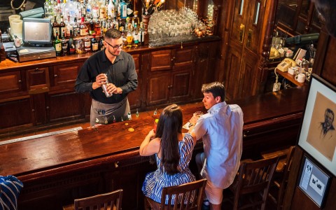 Couple seated at bar in front of bar tender