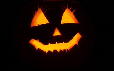 Silhouette of a Jack O Lantern with a candle providing an orange glow