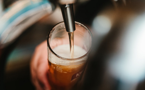 beer being poured into a glass from a tap