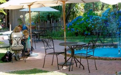 courtyard with foundtain and metal tables with umbrella sitting at them