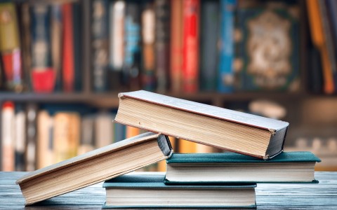 stack of books on table of library