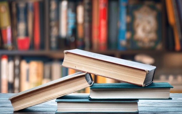 stack of books on table of library