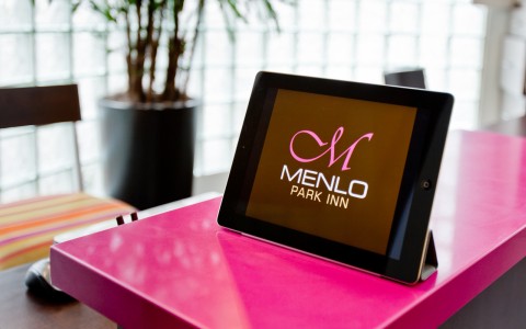 ipad on the check in desk with Menlo logo displayed.