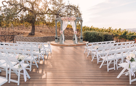 Beautiful wedding venue with numerous white chairs and an altar