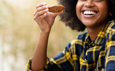 Woman smiling and holding a cookie 