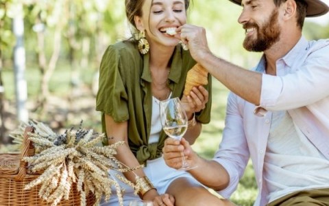 Man feeding a woman during a picnic 