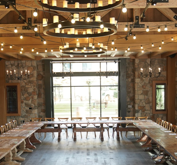stone walled venue with wood rafting ceiling set with farmtables in a large u shape