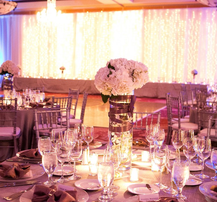 Stunning wedding venue with multiple set up tables and silver chairs 