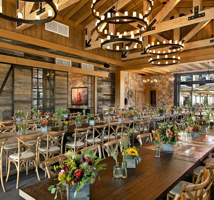 Stunning wedding venue with long tables with several flower centerpieces 