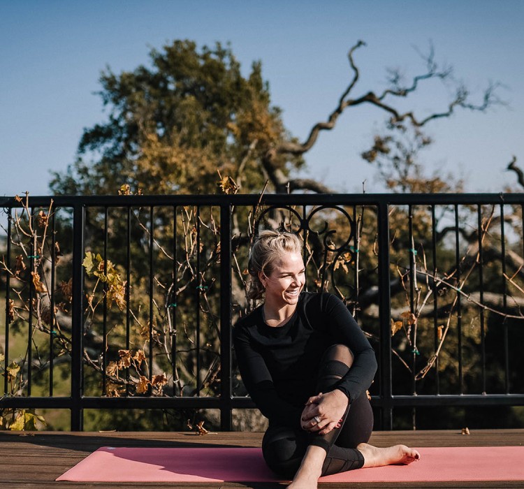 Woman doing yoga on a deck outdoors 
