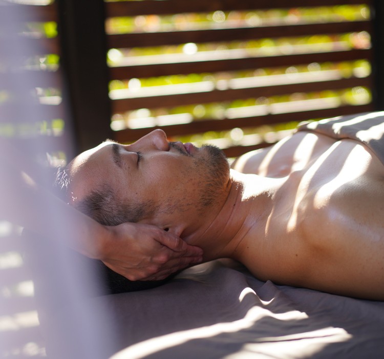 view of a man enjoying a massage treatment at an outdoor spa room