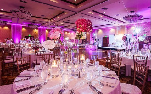 Table with with white tablecloth and a flower centerpiece 