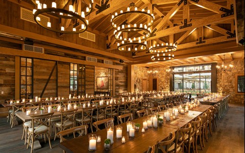 Long wooden tables with lit up candles