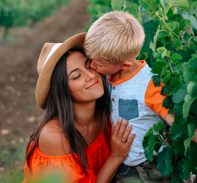 young boy kissing his mother's cheek as they take a tour of the property