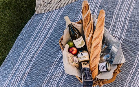 Picnic basket set up with wine and fruits