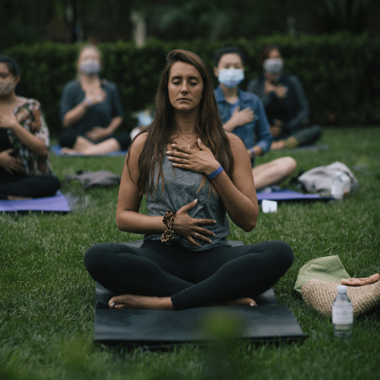 Woman doing a breathing exercise on the lawn