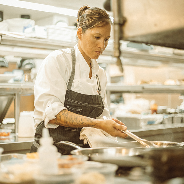 A chef cooking a meal in a pan