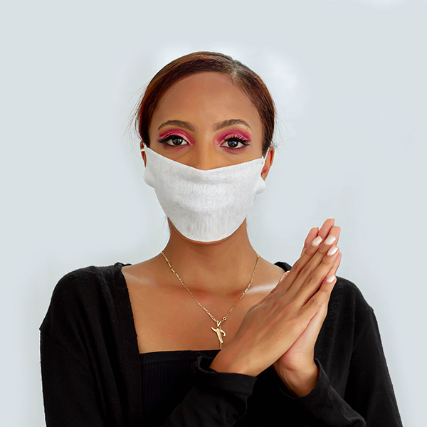 Woman wearing a facemask and holding her hands together