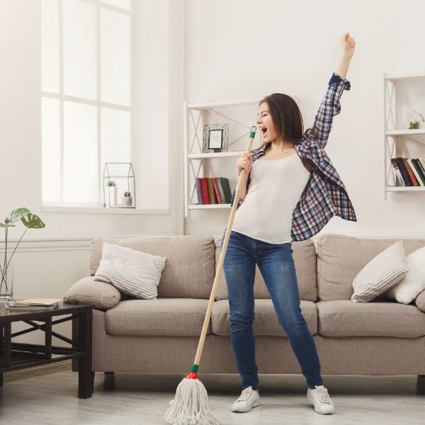 Woman singing and cleaning a room