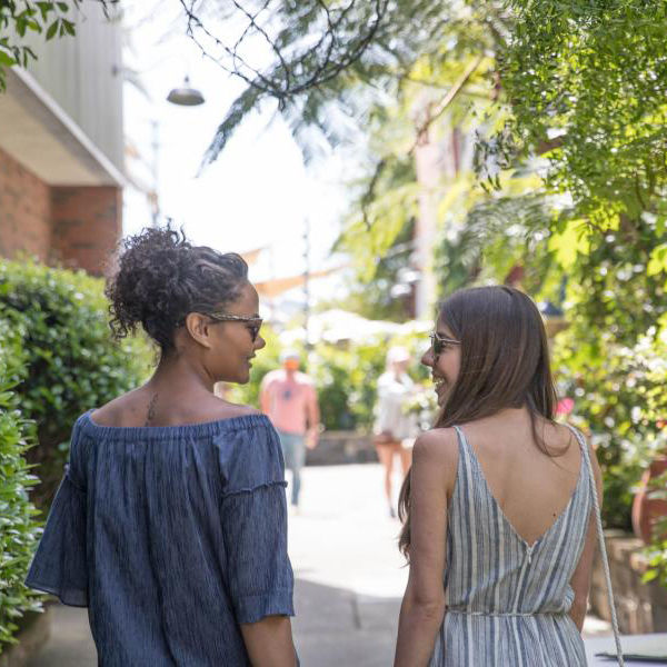 two women having a conversation while taking a stroll outside