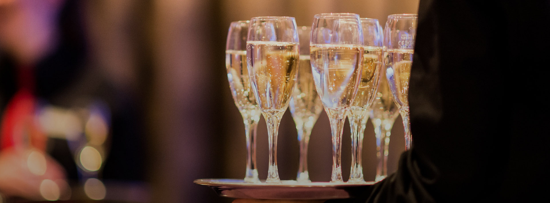 Man holding a tray with various champagne glasses