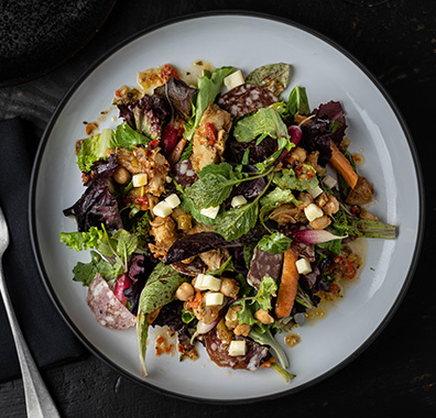 overhead view of a fresh green salad with spring mix and fresh ingredients