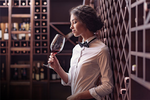 Woman sipping wine in a wine room