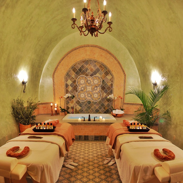 Spa room inside a cave e with two beds and a bath tub
