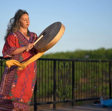 Woman playing a drum outside