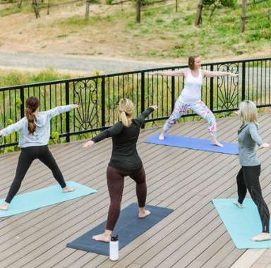 Four women doing yoga on a patio