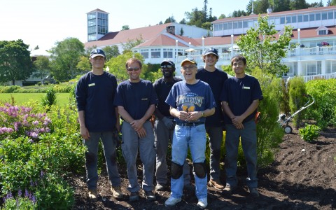a group of men standing in the dirt smiling