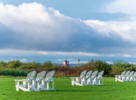 a view of lawn chair ons a a grass with a blue sky