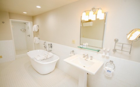 view of a guess bathroom with a mirror and a bathtub