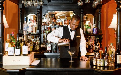 a barman serving a cocktail in a bar 