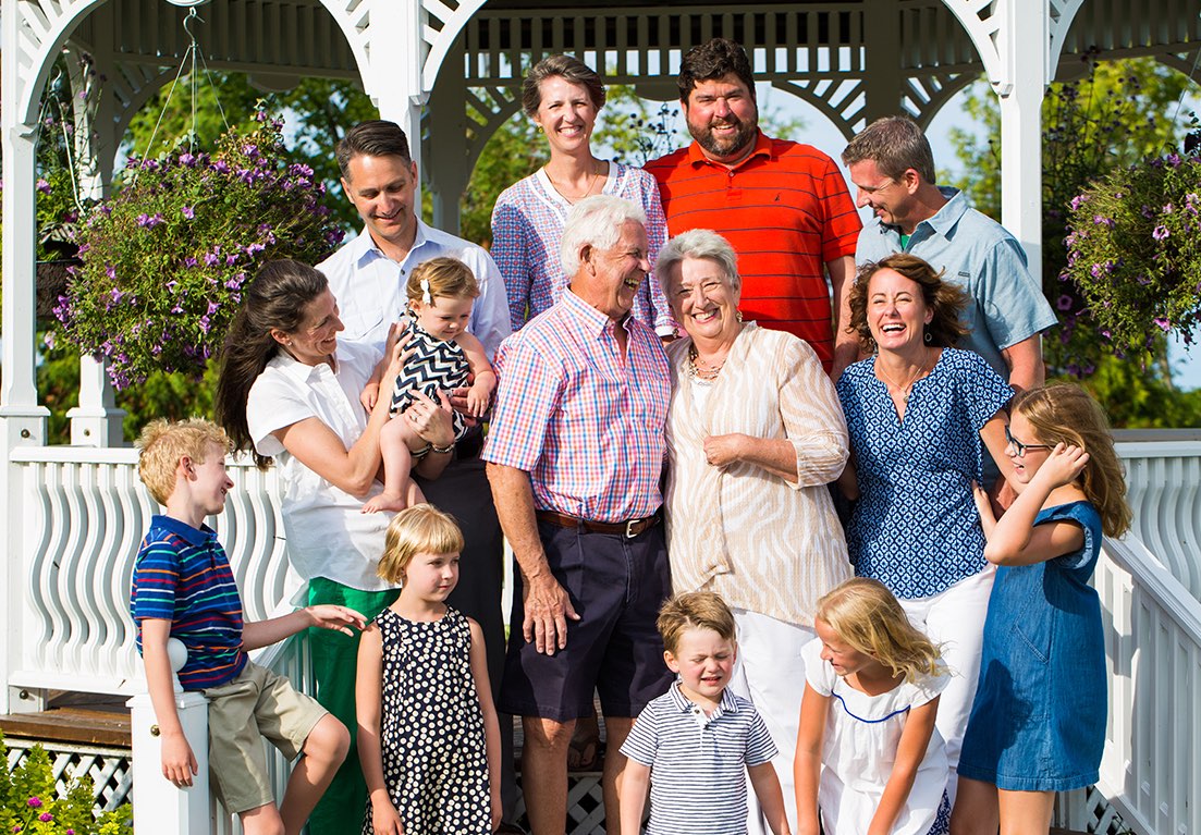 a happy family posing for a picture in front of a garden kiosk