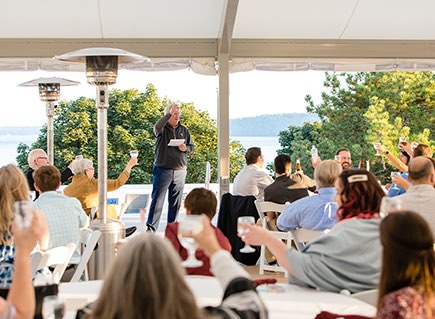 a person in front of a group of people making a toast