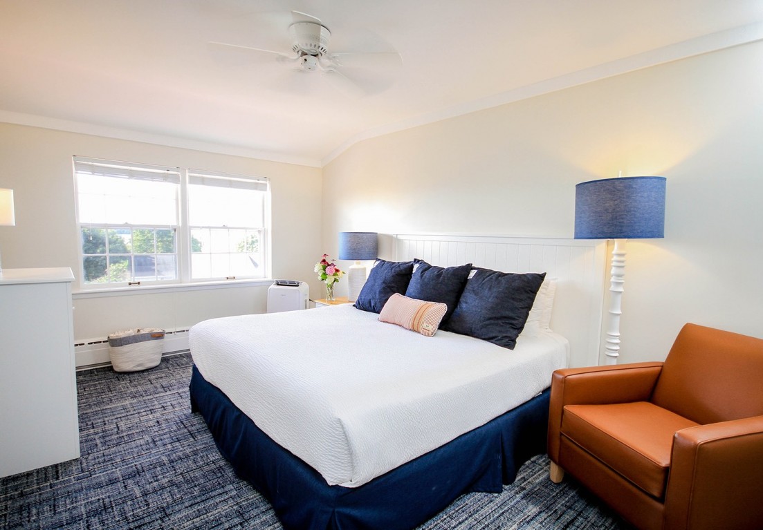 king bed with an orange-brown sofa chair next to it