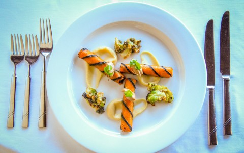 decorative plate of colorful food and silverware next to it