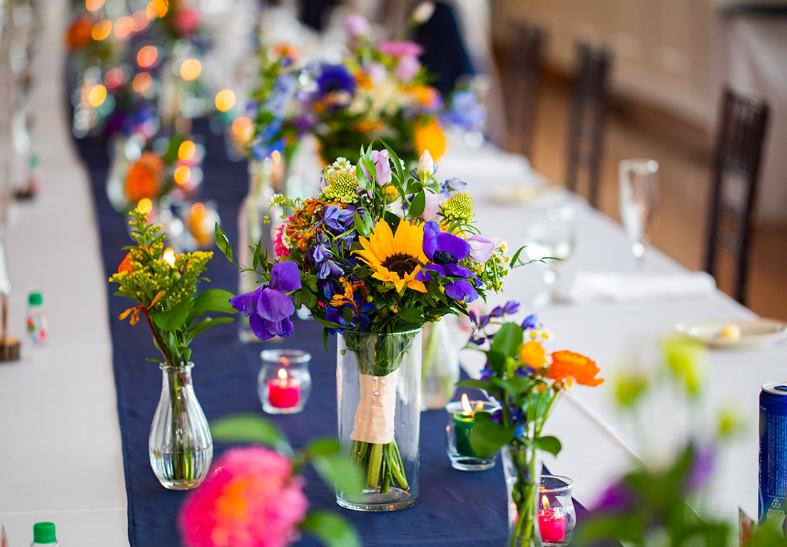 table decorated with a navy blue table runners and flowers in vases