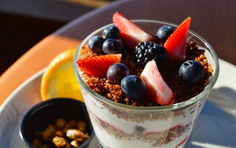 close up of a parfait with blueberries blackberries and strawberries topped on granola