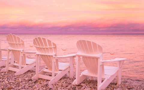 pink skies over the water and lawn chairs