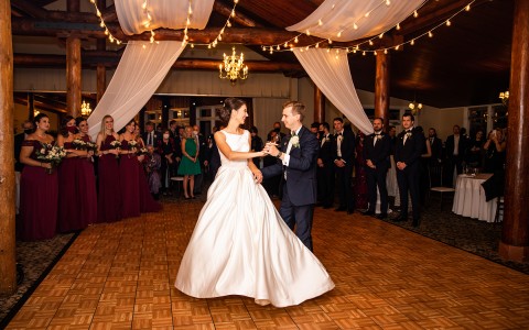 a bride and groom holding hands while dancing