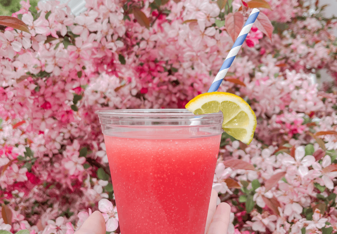 Person holding a lemonade with a striped straw