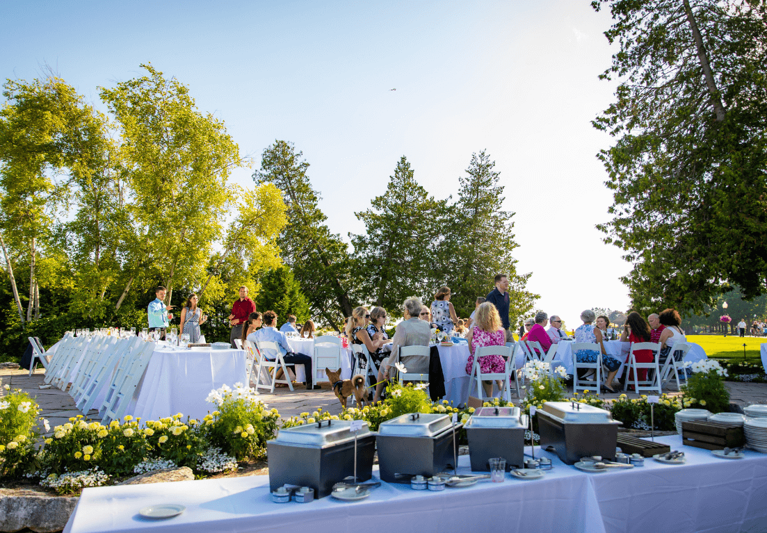 View of the courtside patio with a buffet and guests gathered together