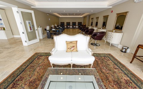 white couch with rows of salon chairs in background